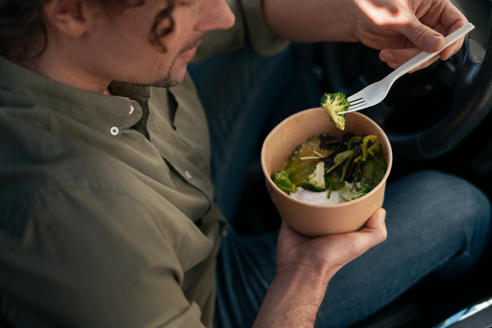 Hombre comiendo una ensalada que se ha comprado en un sitio de comidas para llevar en alicante